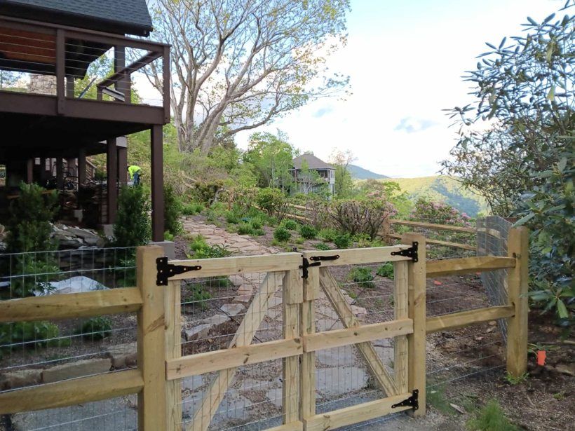 Deck board fence with custom wood gate and wire backing by Mountain Fence and Deck